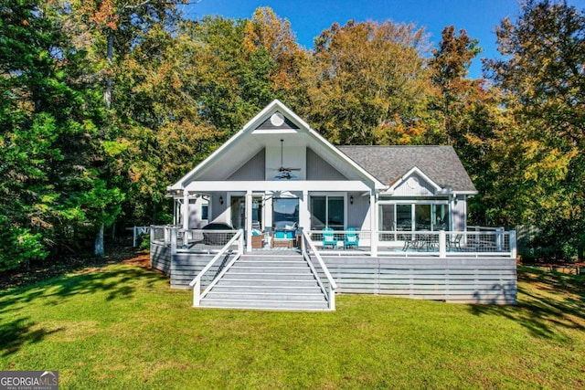 back of property with ceiling fan and a lawn