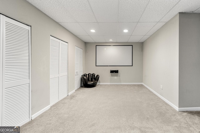 carpeted cinema with a drop ceiling