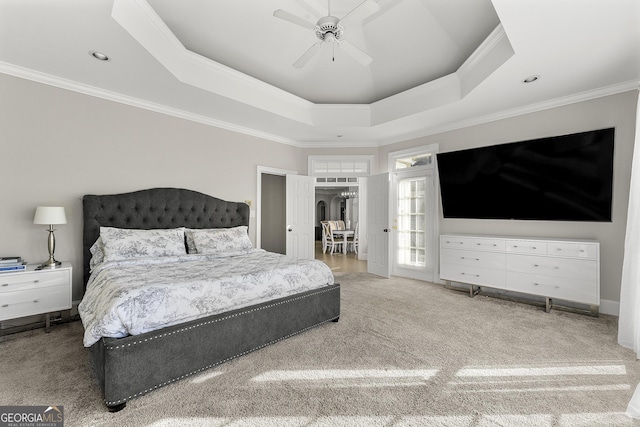 bedroom featuring ceiling fan, ornamental molding, carpet floors, and a tray ceiling