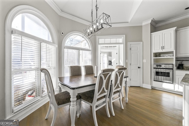 dining space featuring crown molding, an inviting chandelier, and hardwood / wood-style flooring