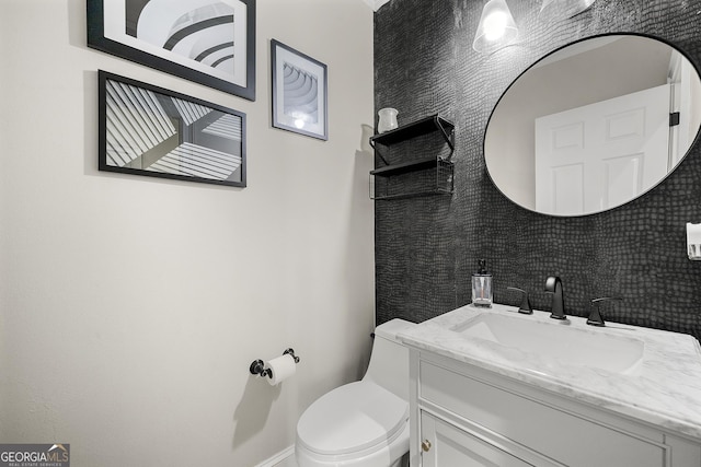 bathroom with toilet, decorative backsplash, and vanity