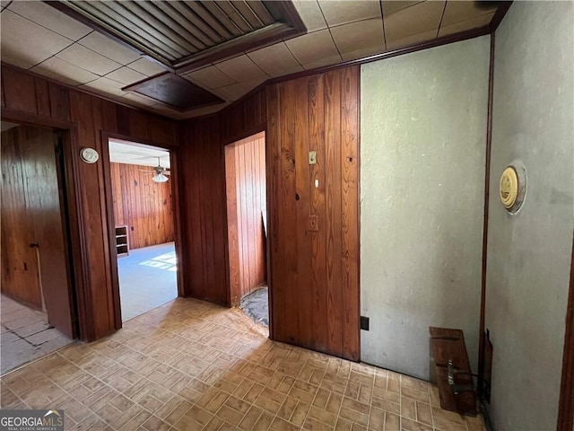 hallway featuring a notable chandelier and wood walls