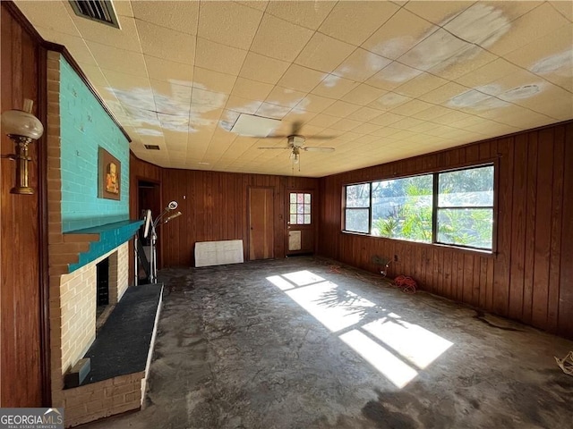 unfurnished living room featuring ceiling fan and a fireplace