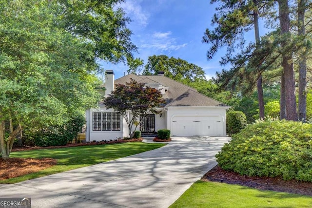 view of front of home with a garage and a front lawn