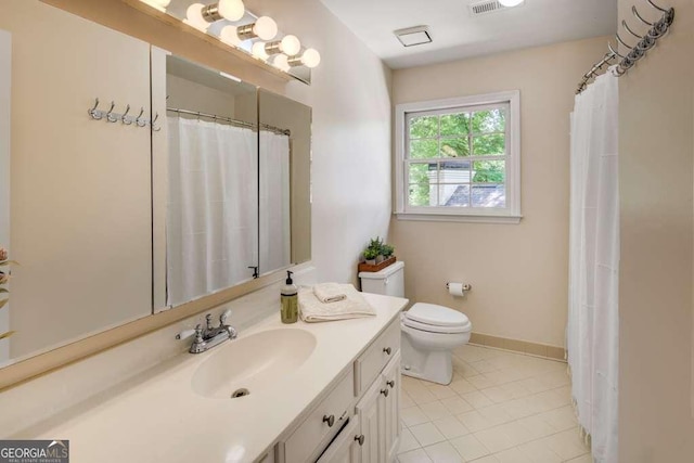 bathroom with tile patterned flooring, vanity, and toilet