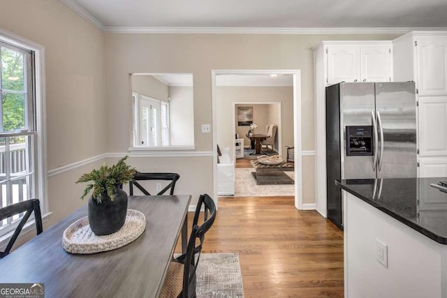 dining space with light wood-type flooring and crown molding