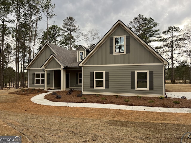 craftsman-style home with a shingled roof and board and batten siding