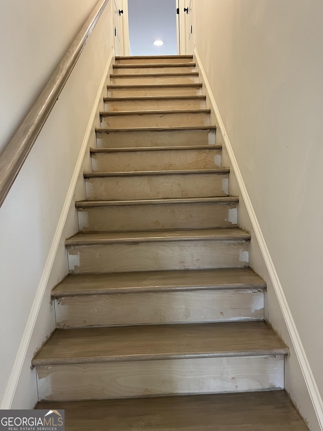 stairs featuring wood finished floors