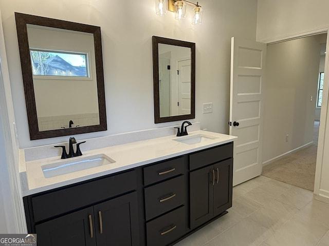 full bath featuring double vanity, a sink, and baseboards