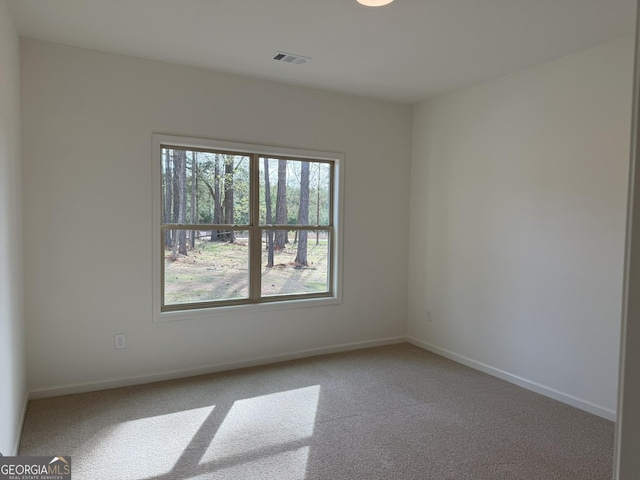 carpeted spare room with baseboards and visible vents