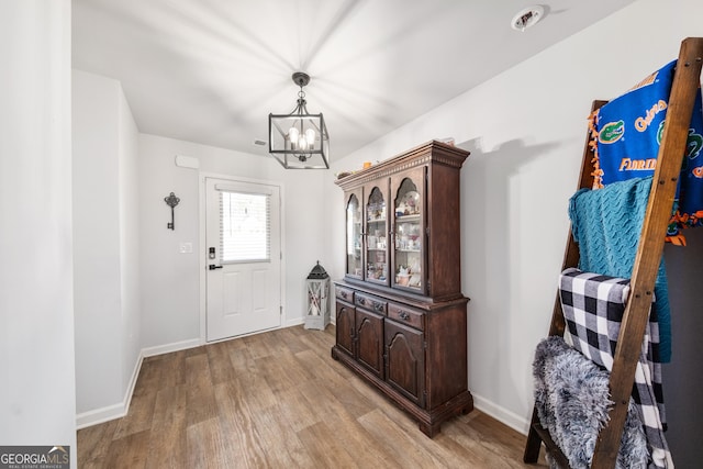 foyer featuring an inviting chandelier and light hardwood / wood-style flooring