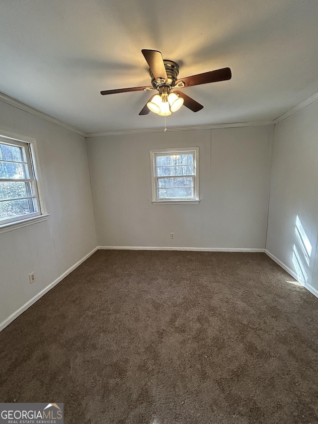 unfurnished room with ornamental molding, dark carpet, baseboards, and a ceiling fan