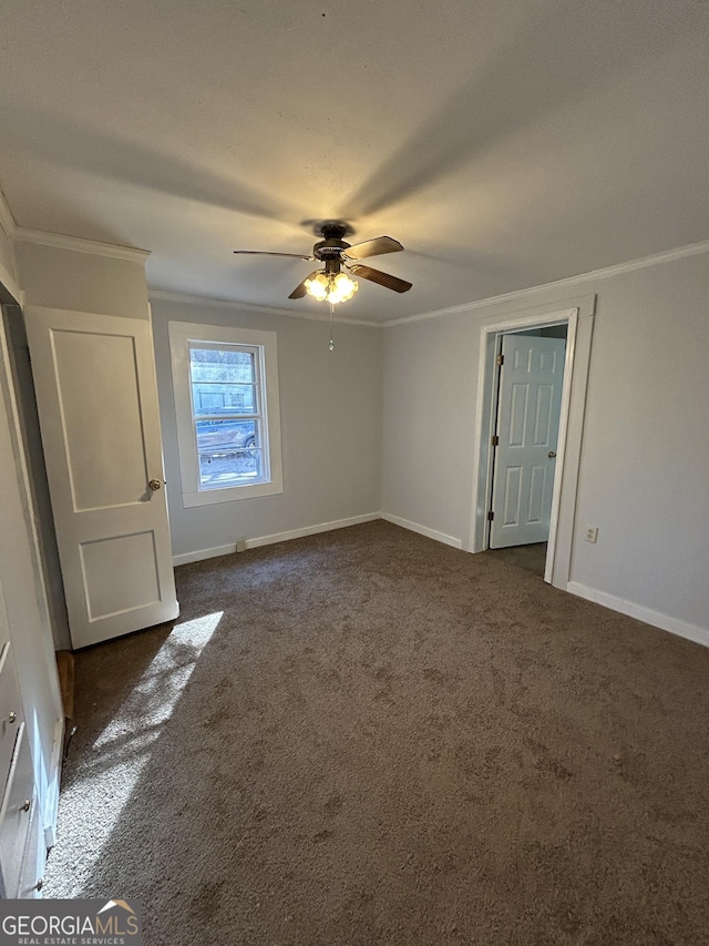 unfurnished bedroom with baseboards, dark colored carpet, and crown molding