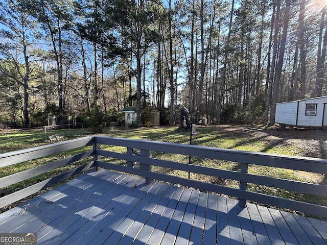 deck featuring an outdoor structure, a storage shed, and a lawn