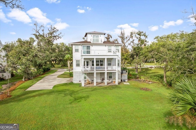 back of house with a balcony, a yard, and a patio