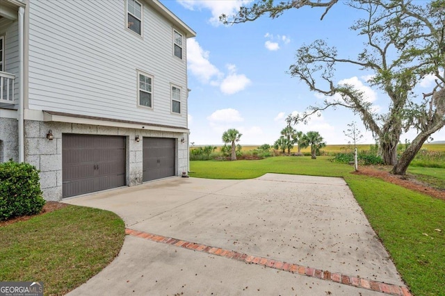 view of side of home with a lawn and a garage