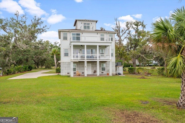 back of house featuring a balcony and a lawn