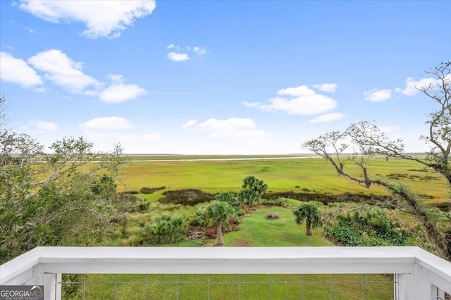 view of yard with a balcony and a rural view