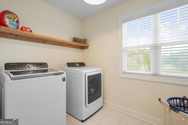 washroom featuring washer and clothes dryer and light tile patterned floors