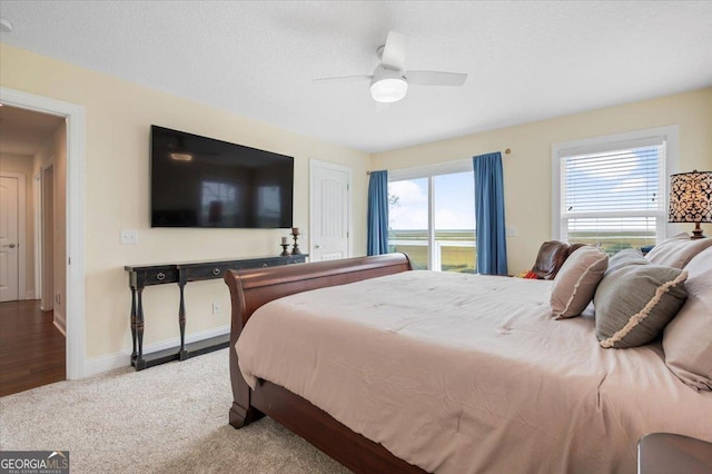 carpeted bedroom with ceiling fan and a textured ceiling