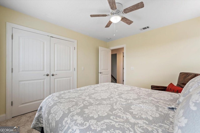 carpeted bedroom featuring ceiling fan and a closet