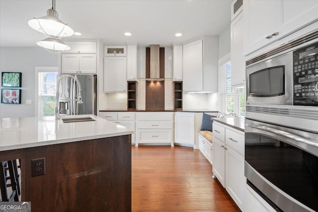 kitchen featuring appliances with stainless steel finishes, tasteful backsplash, white cabinetry, and hanging light fixtures