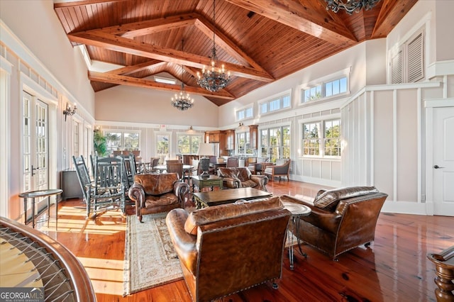 sunroom with french doors, lofted ceiling with beams, an inviting chandelier, and wood ceiling