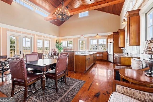 dining room with hardwood / wood-style flooring, beam ceiling, high vaulted ceiling, and a chandelier