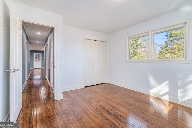 unfurnished bedroom featuring dark wood-type flooring and a closet