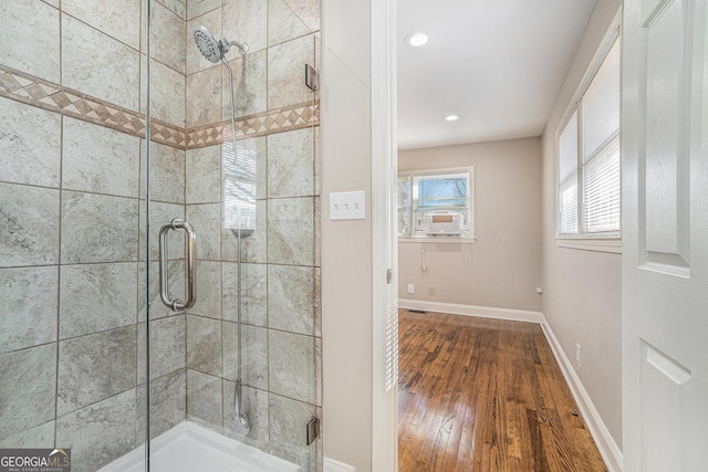 bathroom featuring cooling unit, a shower with shower door, and hardwood / wood-style floors