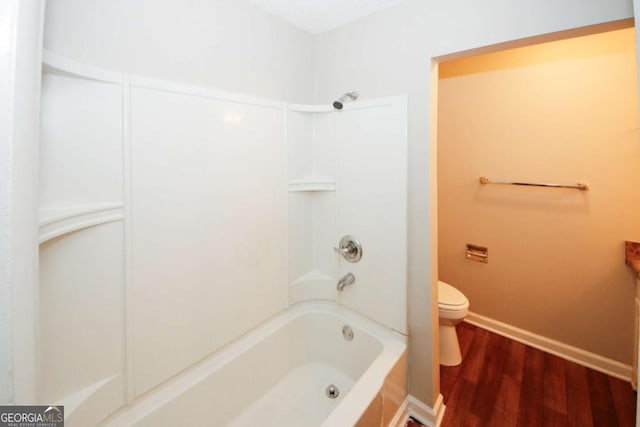 bathroom with shower / washtub combination, hardwood / wood-style floors, and toilet