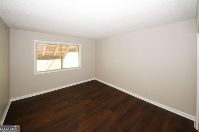 unfurnished room with dark hardwood / wood-style floors