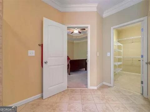 hall with crown molding and light tile patterned flooring