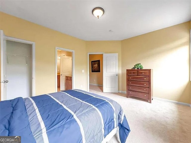 carpeted bedroom with connected bathroom and a closet