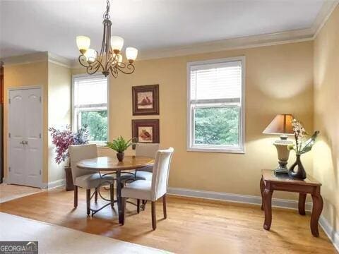 dining room with a chandelier, light hardwood / wood-style floors, and crown molding