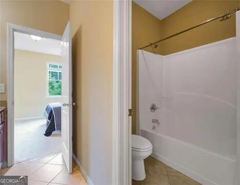 full bathroom with tile patterned floors, toilet, vanity, and washtub / shower combination