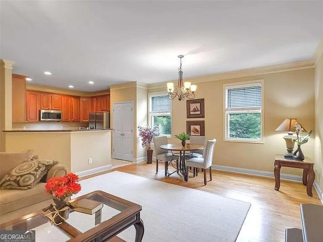 living room featuring a chandelier, light wood-type flooring, and crown molding