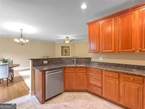 kitchen with dark stone counters, ceiling fan with notable chandelier, sink, stainless steel dishwasher, and kitchen peninsula