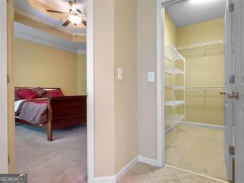 bathroom with ceiling fan and tile patterned flooring