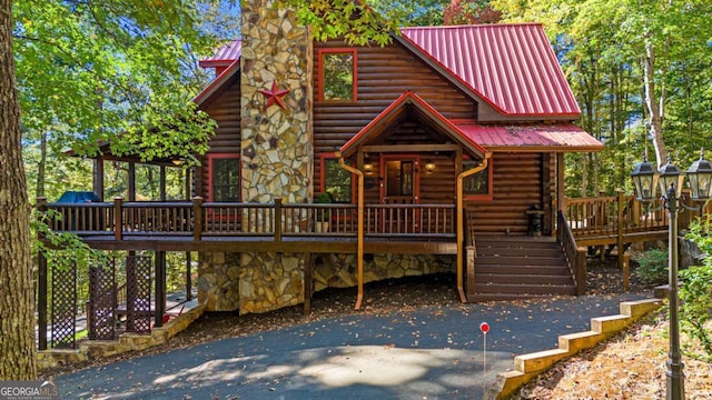 log cabin with a wooden deck