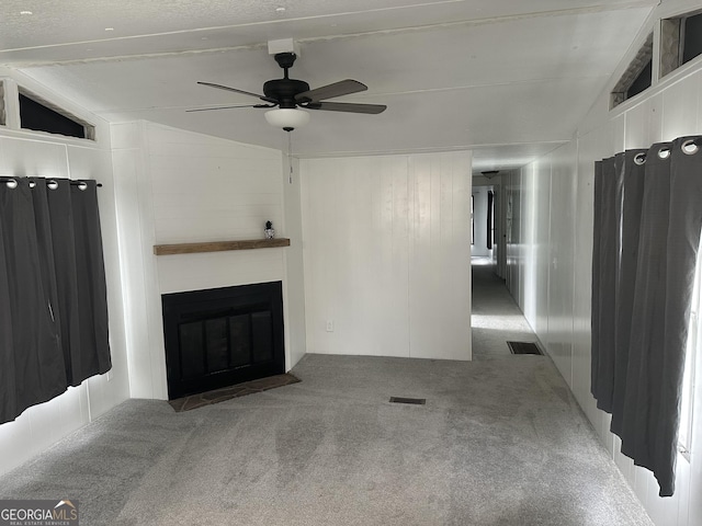 unfurnished living room featuring carpet flooring, ceiling fan, and lofted ceiling