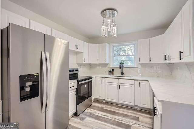 kitchen with sink, tasteful backsplash, pendant lighting, white cabinets, and appliances with stainless steel finishes