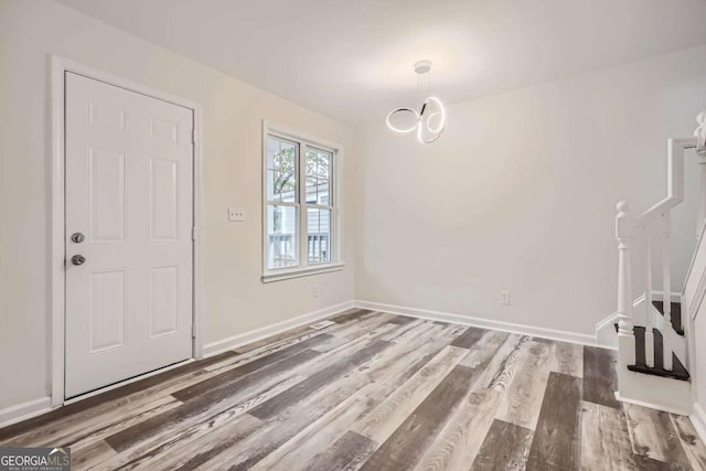 entryway featuring wood-type flooring and a notable chandelier