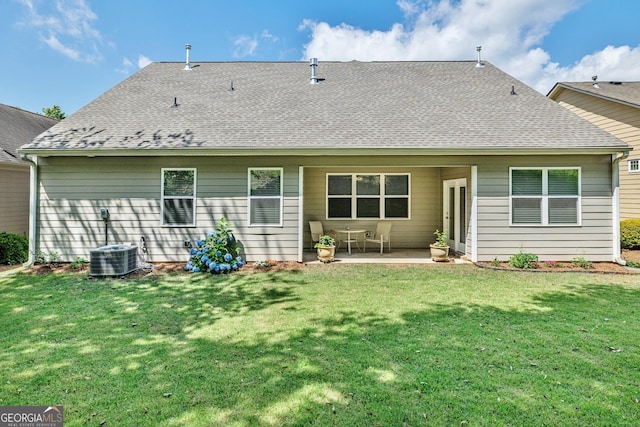 rear view of property featuring a lawn, a patio area, and central AC