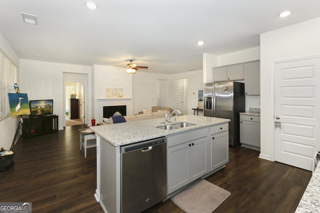 kitchen with gray cabinetry, a kitchen island with sink, sink, ceiling fan, and stainless steel appliances