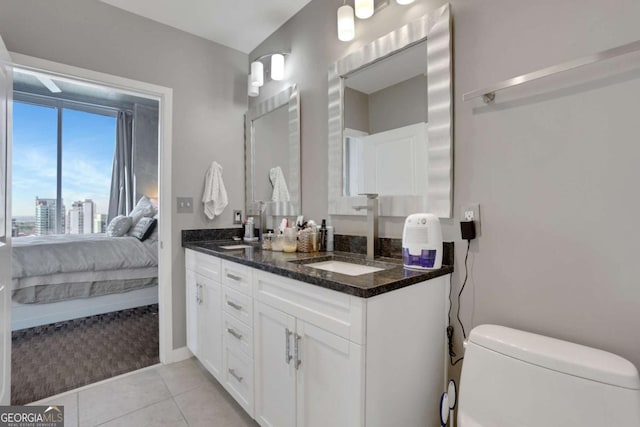 bathroom featuring tile patterned flooring, vanity, and toilet