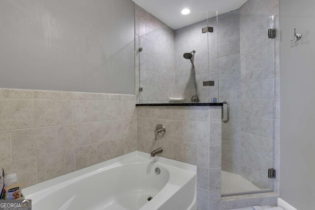 bathroom featuring separate shower and tub