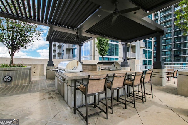 view of patio featuring grilling area, ceiling fan, and an outdoor kitchen