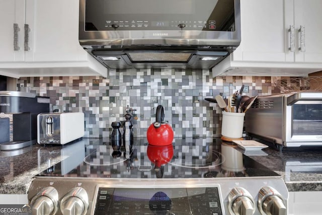 kitchen with backsplash, white cabinetry, and range hood