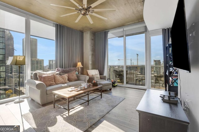 living room featuring light hardwood / wood-style flooring, expansive windows, and ceiling fan